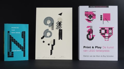 Three items in a row: a small blue booklet, a black and white print and a mostly white book cover with black and pink illustrations and text.